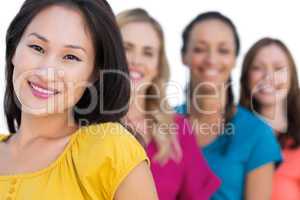 Smiling models in a line posing with focus on asian model