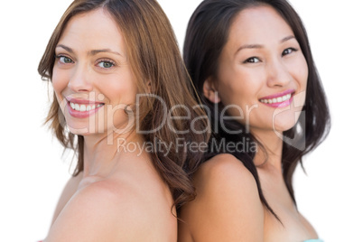 Smiling beautiful nude models posing back to back