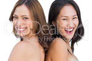 Laughing beautiful nude models posing back to back