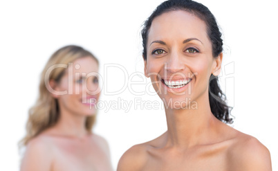 Smiling brunette on foreground with blonde on background