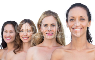 Smiling nude models posing in a line looking at camera