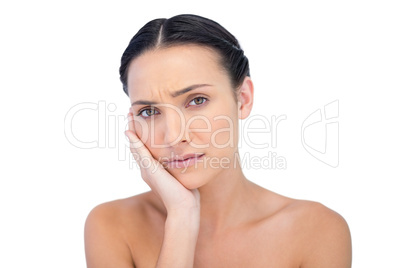 Young woman posing while touching her cheek