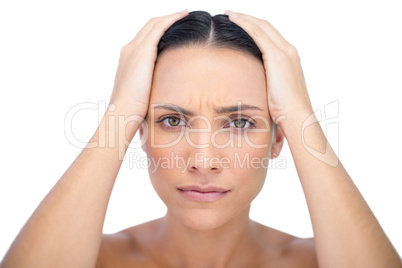 Young woman with headache touching her forehead