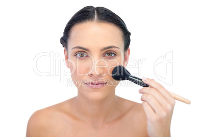 Natural model applying makeup on her face