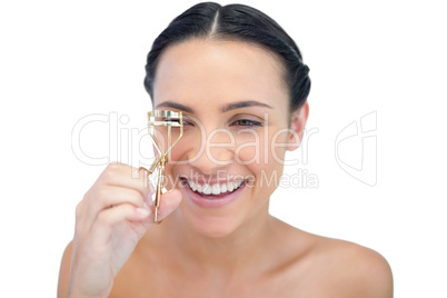 Smiling natural model with eyelash curler