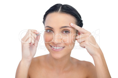 Smiling young model holding tweezers