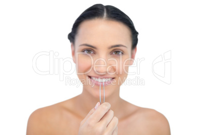 Cheerful young brunette with tweezers