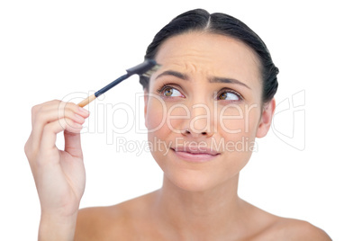 Curious young model using eyebrow brush