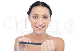 Cheerful natural young model using nail file