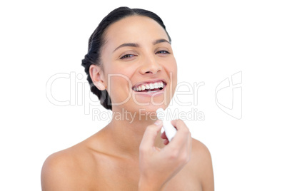 Cheerful young natural model with lip balm