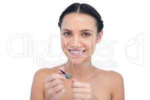 Cheerful natural model using nail clippers