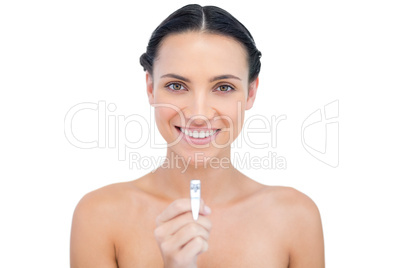 Cheerful young model holding nail clippers