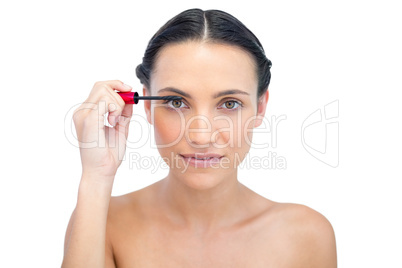 Young brunette applying mascara