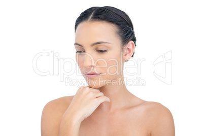 Thoughtful nude model posing hand on her chin