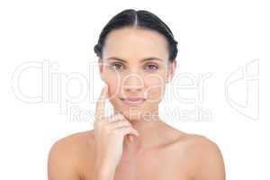 Gorgeous nude model posing finger on her cheek