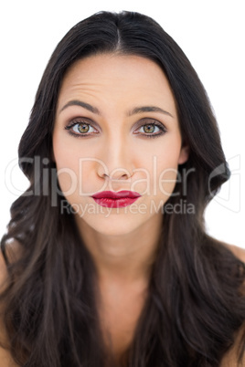 Doubtful dark haired woman with red lips
