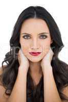 Dark haired woman with red lips touching her neck