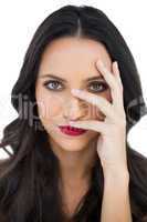 Dark haired woman with red lips hiding her face