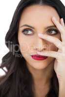 Thoughtful dark haired woman with red lips hiding her face