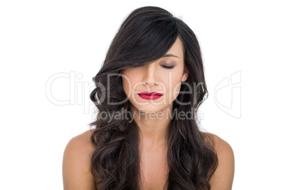 Thoughtful dark haired woman posing closing eyes