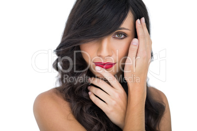 Glamorous brunette posing finger on her red lips