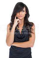 Pensive elegant brown haired model posing with finger on her che