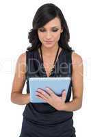 Elegant brown haired model typing on tablet