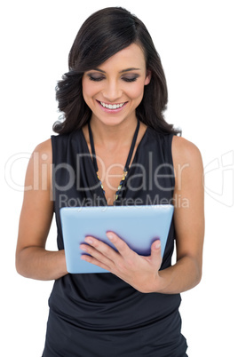 Smiling elegant brown haired model typing on tablet