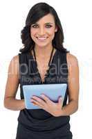 Smiling elegant brown haired model using tablet-computer