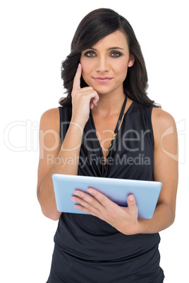 Pensive elegant brown haired model holding tablet