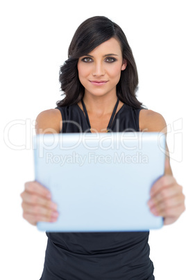 Peaceful elegant brown haired model holding tablet in front of h