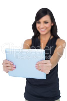 Smiling elegant brown haired model looking at her tablet pc