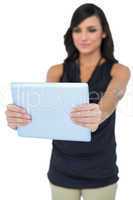 Elegant dark haired model looking at her tablet pc