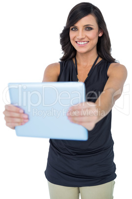 Smiling elegant dark haired model holding her tablet