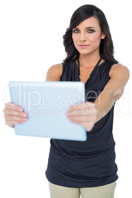Serious elegant dark haired model holding her tablet