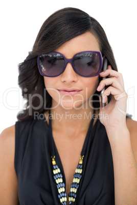 Elegant brunette wearing sunglasses on the phone