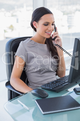 Smiling sexy businesswoman answering phone Smiling sexy businesswoman answering phone