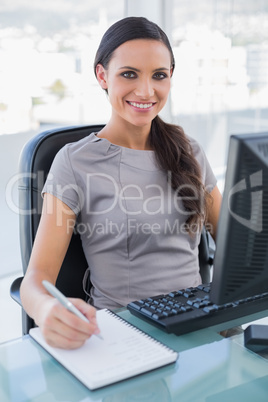 Smiling businesswoman taking notes