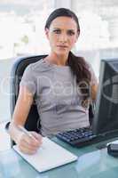 Frowning gorgeous businesswoman writing