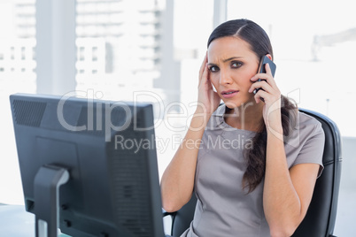 Businesswoman with headache having a phone conversation