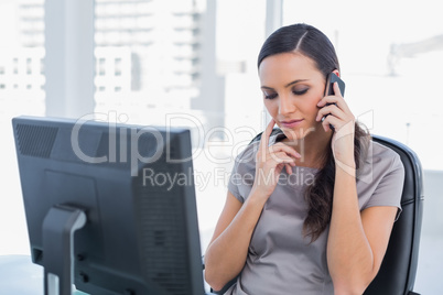 Pensive attractive businesswoman having a phone conversation