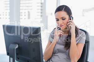 Pensive attractive businesswoman having a phone conversation