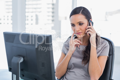 Thoughtful attractive businesswoman having a phone conversation