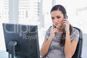 Thoughtful attractive businesswoman having a phone conversation