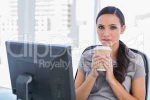Serious attractive businesswoman holding coffee