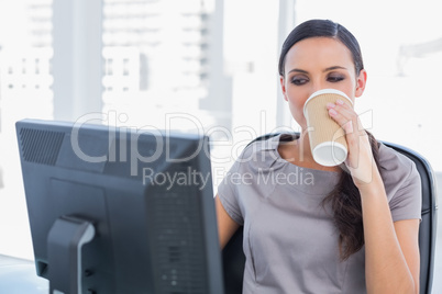 Attractive businesswoman drinking coffee and working