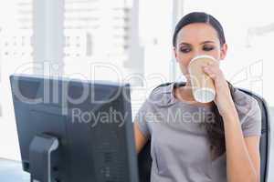 Attractive businesswoman drinking coffee and working