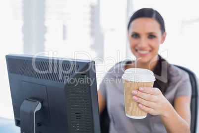 Attractive businesswoman offering coffee to camera