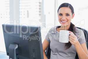 Smiling attractive businesswoman holding mug