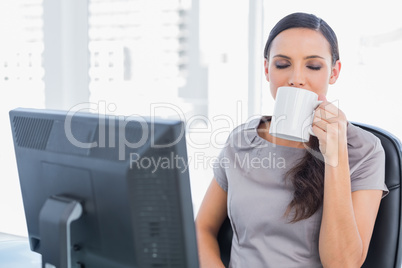 Smiling attractive businesswoman drinking tea